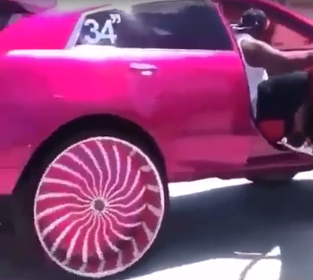 Een roze auto met een roze velg erop en wielen van 34 inch.