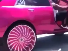 Een roze auto met een roze velg erop en wielen van 34 inch.