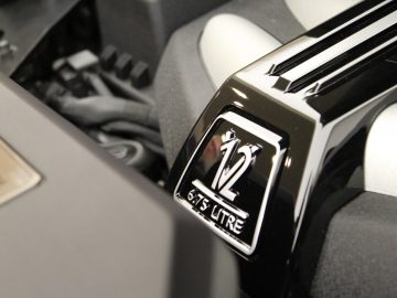 De motorruimte van een Rolls-Royce Phantom met een logo erop.