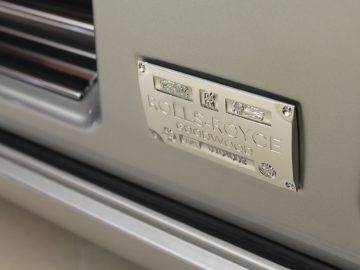 Nieuwe Rolls-Royce Phantom-badge aan de zijkant van een zilveren auto, een monument van een auto.
