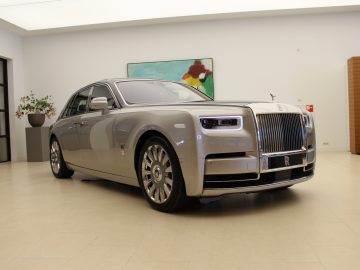 Een zilveren Rolls-Royce Phantom staat geparkeerd in een kamer.
