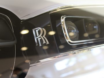Een close-up van een nieuw Rolls-Royce Phantom-embleem op een auto.