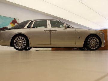 Een zilveren Rolls-Royce Phantom staat geparkeerd in een kamer.