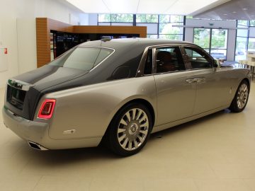 Een Rolls-Royce Phantom staat geparkeerd in een showroom.