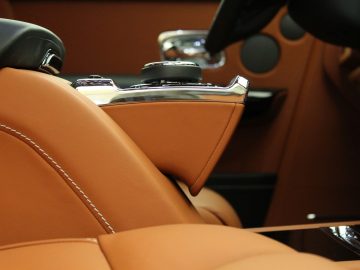 Het interieur van een Rolls-Royce Phantom met bruin lederen stoelen.