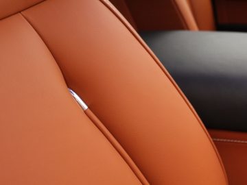 Een close-up van een leren stoel in een auto.