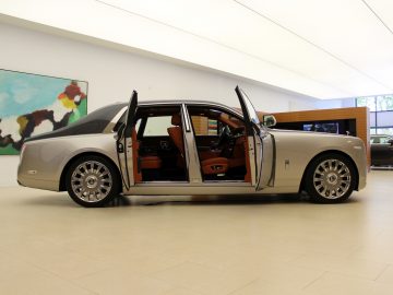 Een zilveren nieuwe Rolls-Royce Phantom geparkeerd in een showroom.