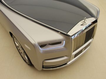 De voorkant van een auto, een zilveren Rolls-Royce Phantom.