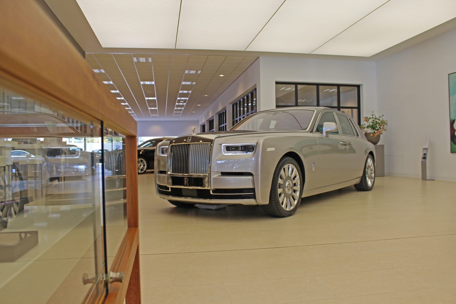 Een Rolls-Royce Phantom staat geparkeerd in een autoshowroom.