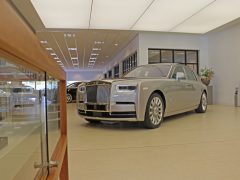 Een Rolls-Royce Phantom staat geparkeerd in een autoshowroom.