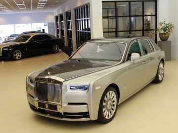 Een zilveren nieuwe Rolls-Royce Phantom staat geparkeerd in een showroom.