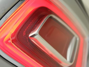 Een close-up van een rood achterlicht op een zilveren Rolls-Royce Phantom.