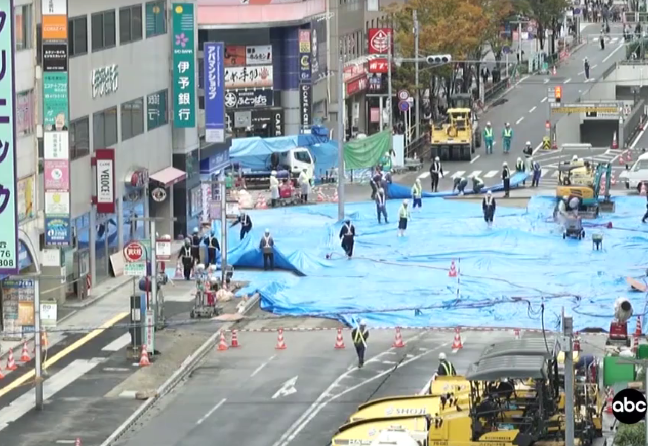 Een stadsstraat is bedekt met blauw zeil vanwege een gigantisch zinkgat.