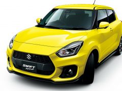 Een gele Suzuki Swift Sport wordt getoond op een witte achtergrond, met extra details beschikbaar op extra foto's.