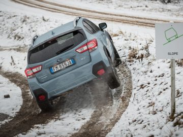 Een blauwe Subaru XV rijdt over een besneeuwde weg.