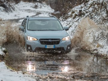 De Subaru XV rijdt door een besneeuwd pad.
