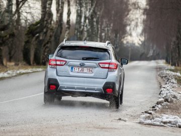 Een Subaru XV die over een besneeuwde weg rijdt.
