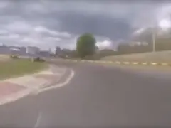Een video van de auto van Max Verstappen die over een circuit rijdt met een wolk op de achtergrond.