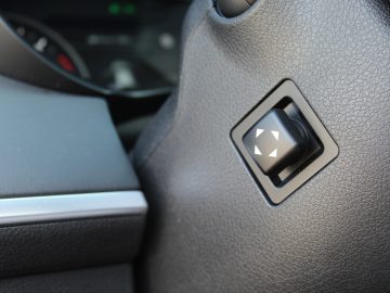 Een close-up van een knop op het stuur van een Kia Stinger.