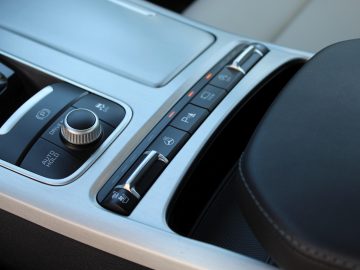 Het dashboard van een Kia Stinger met knoppen en bedieningselementen.