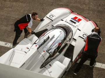 Twee mannen werken aan een Porsche 919 Hybrid Evo-raceauto.
