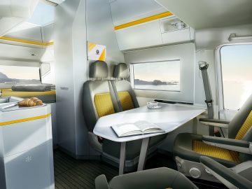 Het interieur van een trein met gele en witte accenten, dat doet denken aan de natte droom van een Nederlandse kampeerder.