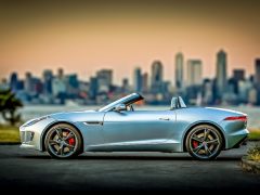 De Jaguar F-Type staat geparkeerd voor de skyline van een stad en lijkt op het beste zomerbehang.