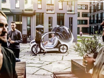Een groep mensen die naast een elektrische auto staan en betrokken zijn bij autodelen.