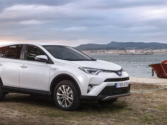 Een eerste editie Toyota RAV4 Hybrid geparkeerd naast een boot.