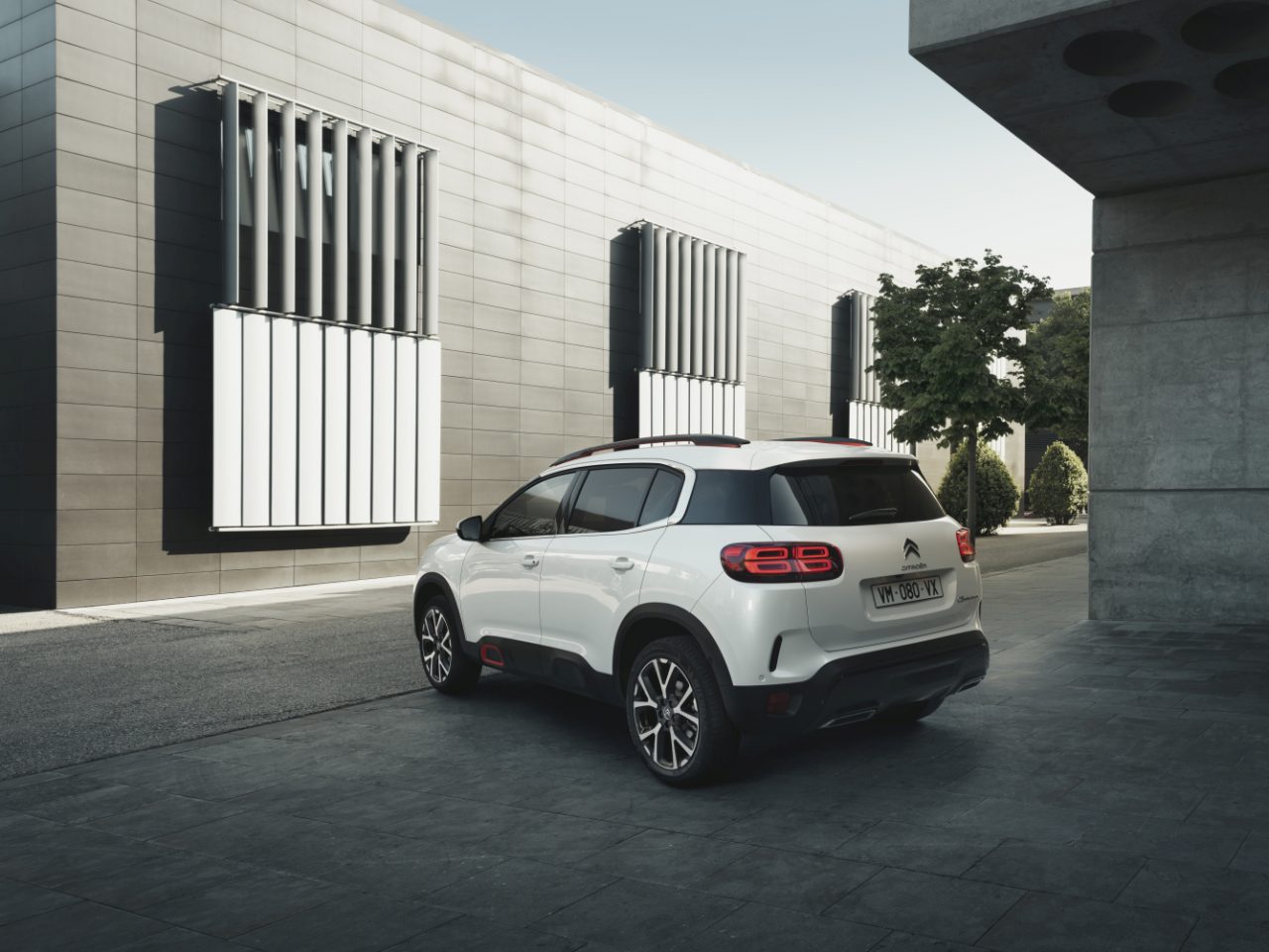 De nieuwe Citroën C5 Aircross staat geparkeerd voor een modern gebouw.