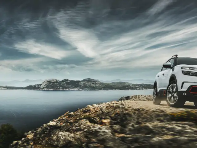 De Citroën C5 Aircross geparkeerd op een rotsachtige klif met uitzicht op de zee.