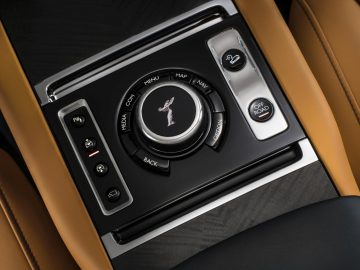 Het dashboard van een Rolls-Royce Cullinan met bruin leer en knoppen.