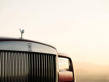 De motorkap van een Rolls-Royce Cullinan bij zonsondergang.