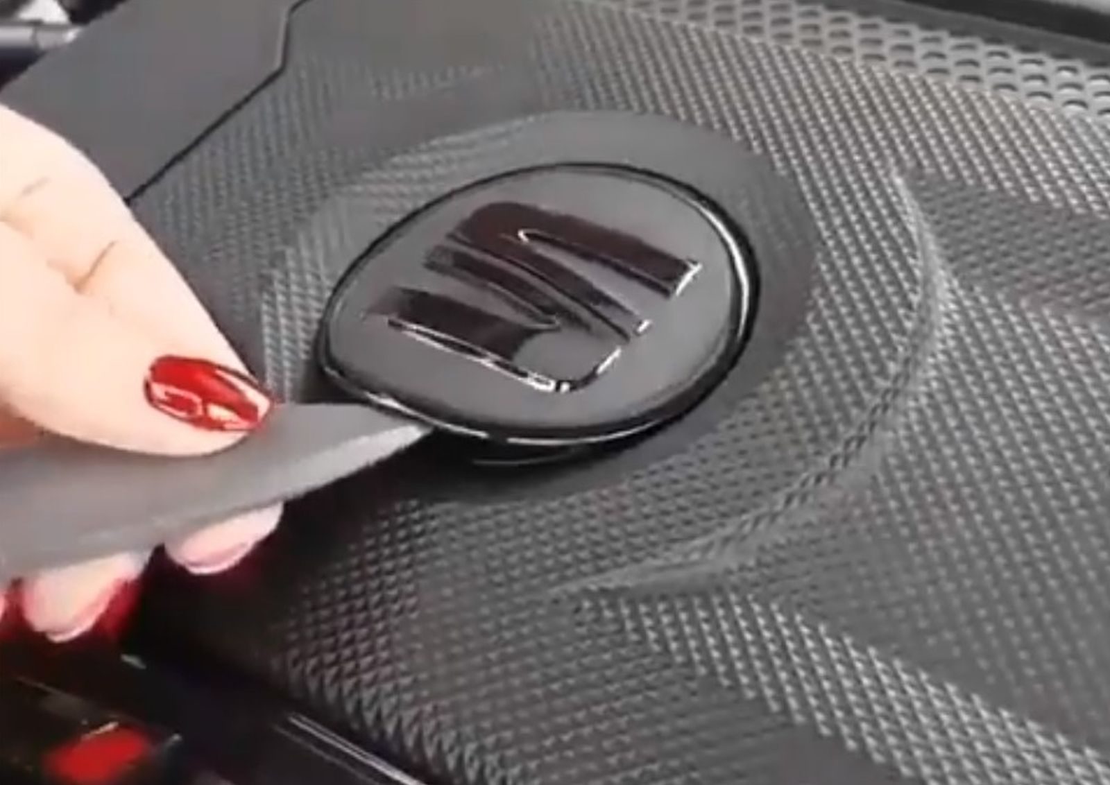 Een persoon die een stuk gereedschap gebruikt om de deur van een auto met een SEAT-logo te openen.