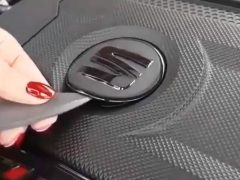 Een persoon die een stuk gereedschap gebruikt om de deur van een auto met een SEAT-logo te openen.