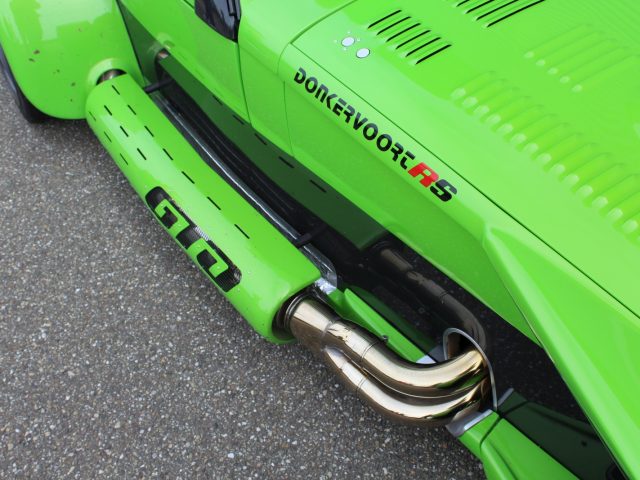 Een groene Donkervoort sportwagen met een zwarte uitlaatpijp.