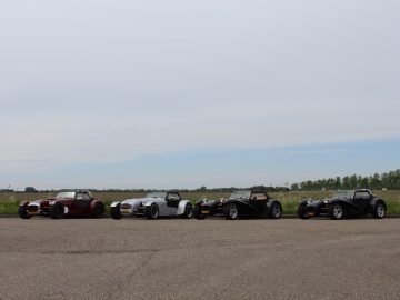 Een groep Donkervoort-auto's geparkeerd op een parkeerplaats.