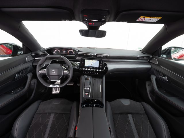 Het interieur van een zwarte Peugeot 508 sportwagen.
