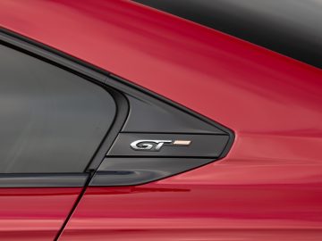De achterdeur van een rode Peugeot 508 met het GT-logo erop.