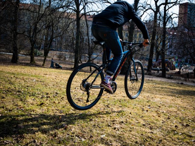 Een man rijdt op een ReTyre-fiets in een park.