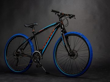 Een zwart-blauwe ReTyre-fiets wordt getoond tegen een donkere achtergrond.