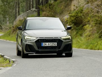 De Audi A1 Sportback rijdt over een bergweg.