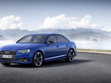De nieuwe Audi A4 sedan staat geparkeerd voor een meer.