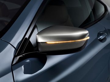 De achteruitkijkspiegel van een blauwe BMW 8 Serie Coupé.