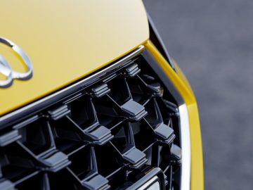 Een close-up van de grille van een gele Audi TT.