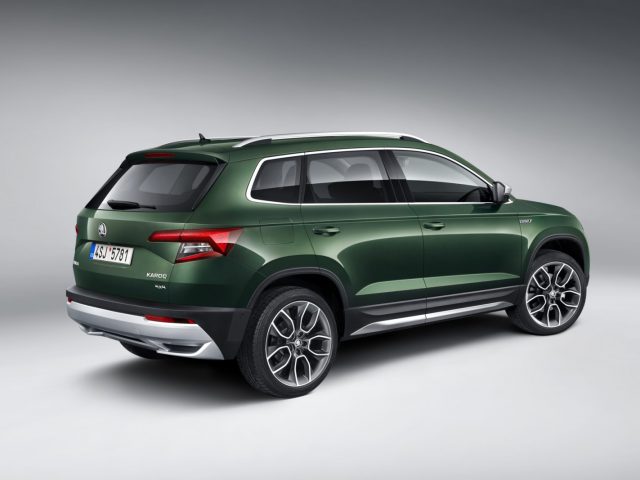 In een studio wordt een groene Skoda Karoq Scout getoond.