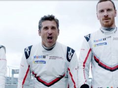 Drie mannen in racepakken staan naast elkaar, naast de Porsche 919 Hybrid.