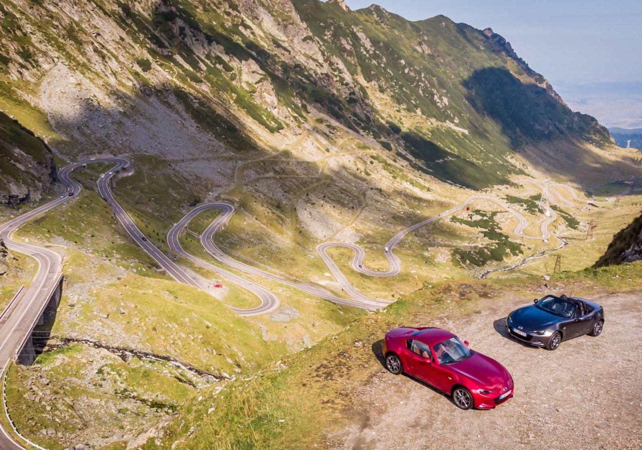Twee rode sportwagens rijden over de Transfagarasan-bergweg.