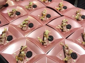 Een groep roze borden met eten erop, te zien op JRE.