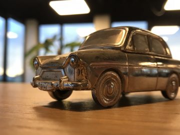 Op een houten tafel staat een speelgoedauto DAF 600.